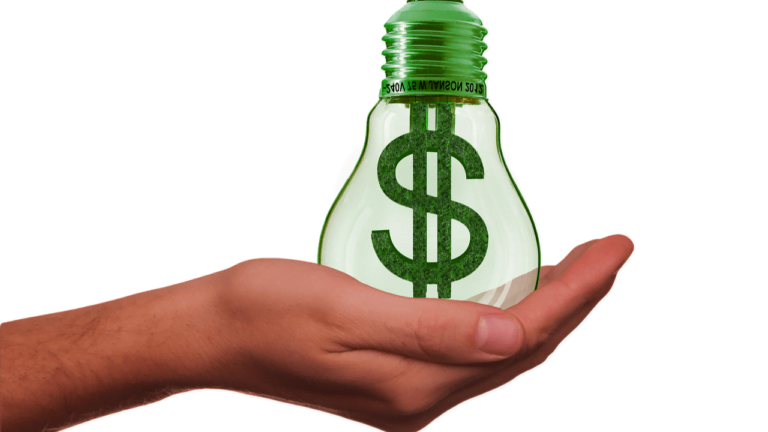 a hand holding a green lightbulb with a dollar sign inside it