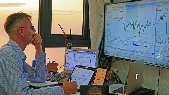 an options trader looking at the computer screen displaying stock charts